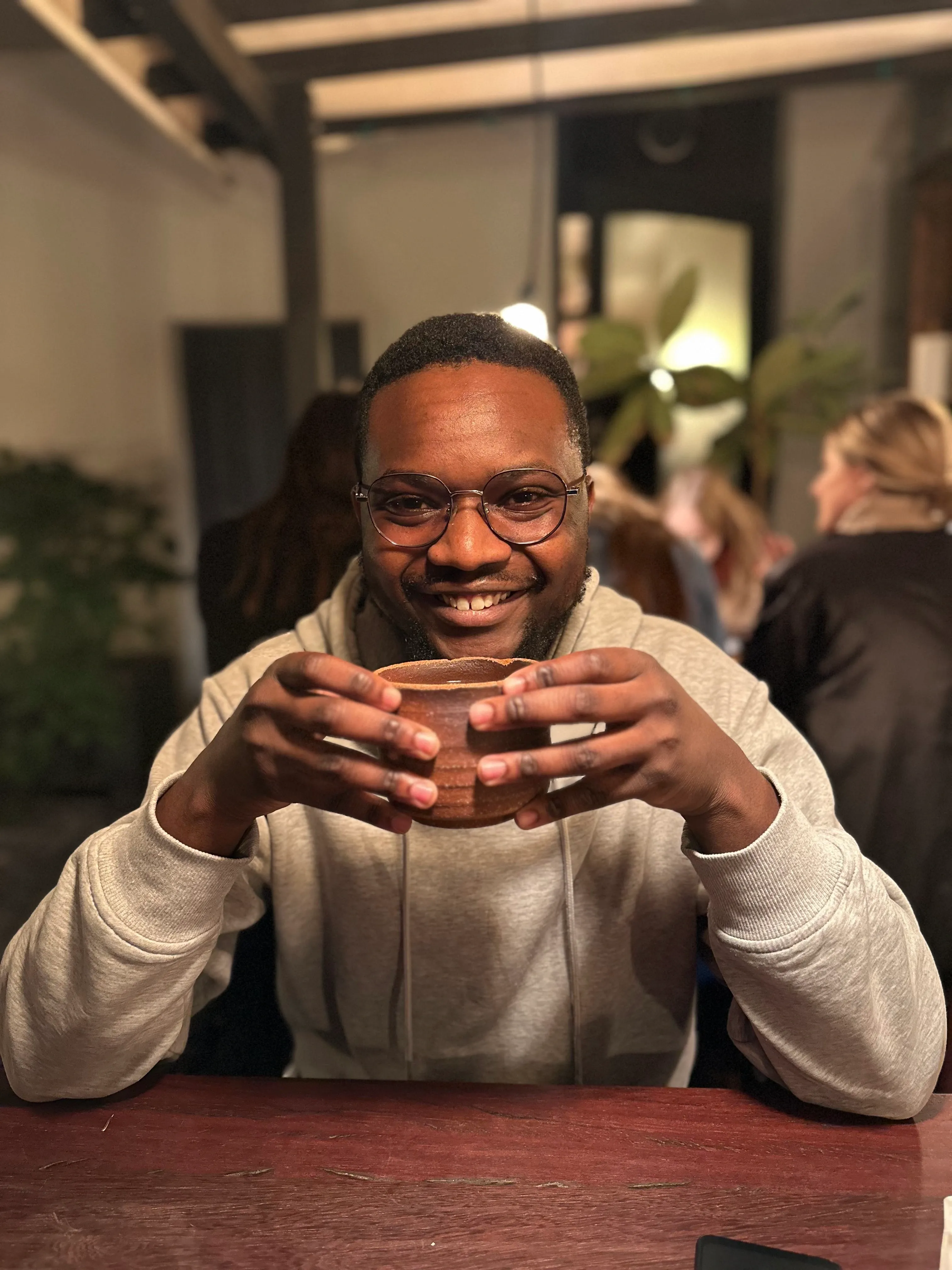 Smiling cat receiving head scratches next to a laptop showing VS Code